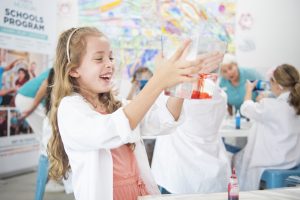 Child holding paint and laughing