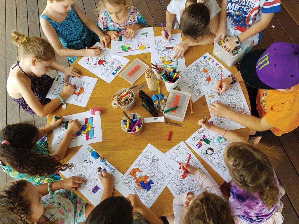 kids colouring drawings around table