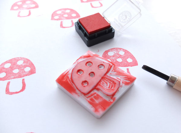 Homemade rubber stamp depicting mushroom with red paint on it