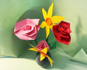 Handmade paper flowers, including roses and daisies, in red, yellow and pink