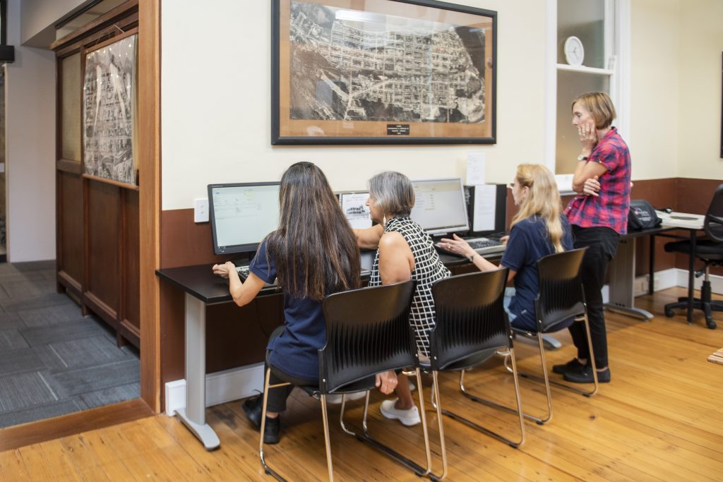 Research Centre staff assisting researchers using computers in the Cairns Historical Society Research Centre