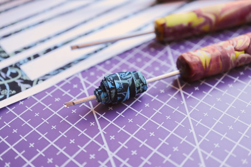 Making decorative beads by rolling and gluing strips of recycled paper